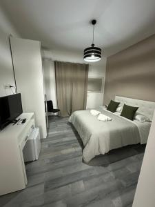 Un dormitorio con una gran cama blanca y un televisor. en La Parthenope suites, en Portici 16 fotos más