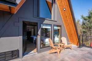 ein Haus mit zwei Stühlen und einem Tisch auf einer Terrasse in der Unterkunft Cove Creek Lodge 220 Lakeside Double Queen Fireplace Room in Oakland + 4 Fotos