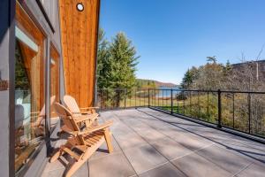 ein Paar Stühle auf dem Balkon eines Hauses in der Unterkunft Cove Creek Lodge 220 Lakeside Double Queen Fireplace Room in Oakland