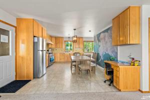 a kitchen with wooden cabinets and a table with chairs at On-Site Kenai River Fishing Soldotna Apartment! in Soldotna