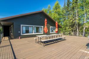 a patio with two picnic tables and two umbrellas at On-Site Kenai River Fishing Soldotna Apartment! in Soldotna