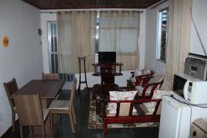 een woonkamer met een eettafel en een magnetron bij Kitnet Praiano- Praia de Olaria in Majé