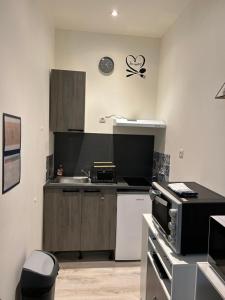 a kitchen with a sink and a stove top oven at Studio Capelet in Vichy