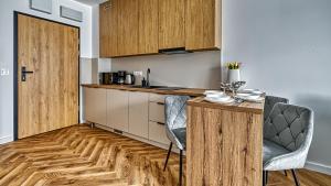 a kitchen with wooden cabinets and a table and chairs at Belle View Szklarska Poręba Strefa SPA - Jacuzzi & Sauna in Szklarska Poręba