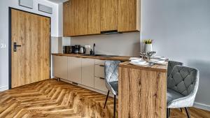 a kitchen with wooden cabinets and a table and chairs at Belle View Szklarska Poręba Strefa SPA - Jacuzzi & Sauna in Szklarska Poręba +13 photos