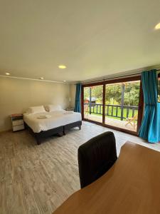 a bedroom with a bed and a large window at Hotel Neyün La Junta in La Junta