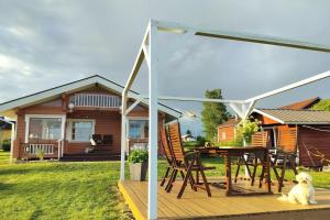a dog sitting on a deck in front of a house at Hirsimökki harjulla in Pudasjärvi