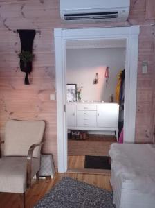 sala de estar con armario blanco y sofá en Hirsimökki harjulla, en Pudasjärvi