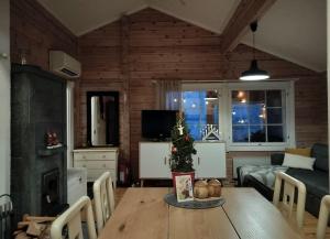 una sala de estar con un árbol de Navidad sobre una mesa en Hirsimökki harjulla, en Pudasjärvi