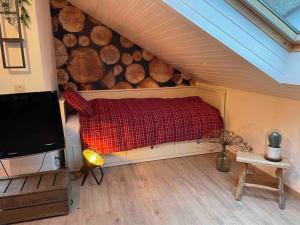a living room with a bed and a wall of logs at Sauerland Lodge Willingen in Willingen