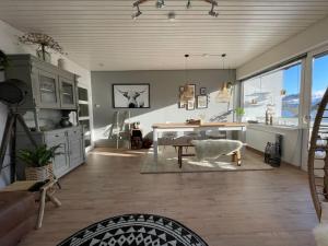 a living room with a table and a room with a view at Sauerland Lodge Willingen in Willingen