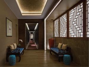 a hallway with two couches and a hallway with windows at Langham Place Guangzhou - Walking distance to Canton Fair in Guangzhou