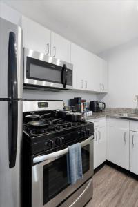 kuchnia z czarną kuchenką i kuchenką mikrofalową w obiekcie Mins 2 Downtown - King Bed - Private Stays w mieście Austin