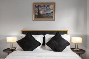 sypialnia z łóżkiem z dwoma lampami i obrazem w obiekcie Mins 2 Downtown - King Bed - Private Stays w mieście Austin