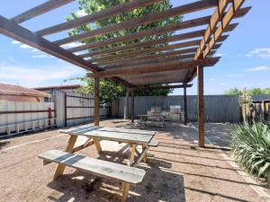 stół piknikowy i ławki pod drewnianą pergolą w obiekcie Mins 2 Downtown - King Bed - Private Stays w mieście Austin