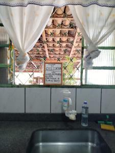 a kitchen counter with a sink and a window at Hostel e Camping da Cris in Carolina