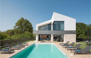 a house with a swimming pool and lounge chairs at Villa Eden in Ližnjan