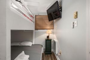 a small room with a bed and a tv on the wall at Stroll to Slopes, Village Area, Ski in-out MtLodge 345 in Snowshoe