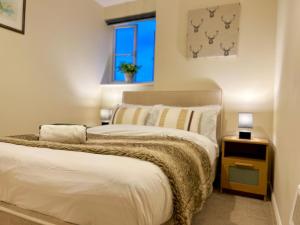 een slaapkamer met een bed en een raam bij Charming, Cosy Escape with Quick Access to Glasgow in Paisley +31 foto's