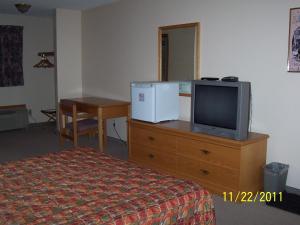 een hotelkamer met een bed en een tv op een dressoir bij Model A Inn in Cranbrook