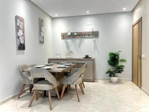 a dining room with a wooden table and chairs at Luxury Apartment by Sea in Martil