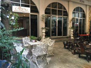 a patio with chairs and a table in front of a building at The Grand Palace Hotel in Bangkok