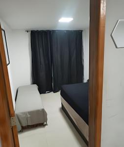 a small room with a bed and a window at otimo apart 2 quartos no recreio dos bandeirantes in Rio de Janeiro