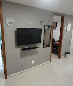 a flat screen tv on a wall in a living room at otimo apart 2 quartos no recreio dos bandeirantes in Rio de Janeiro