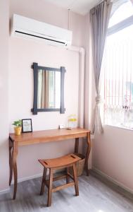 a desk in a room with a mirror and a stool at The Grand Palace Hotel in Bangkok +55 photos
