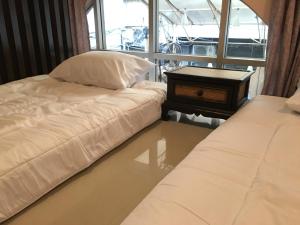 a room with a bed and a night stand next to a window at The Grand Palace Hotel in Bangkok