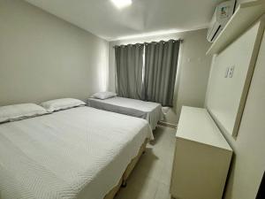 a small room with two beds and a window at Residencial Quinta Lusa em Cond. Valle do Sal - Pox. Gav Resort e Aqualnd - Casas mobilhadas, confortáveis e seguras para passar momentos maravilhosos no Atalaia.. in Salinópolis