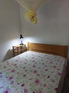 クムルサティバにあるCasa Passarinhosのベッドルーム1室(花柄のベッドカバー付)