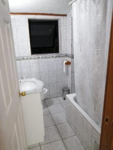 a bathroom with a toilet and a sink and a tub at Javiera Centro Osorno in Osorno