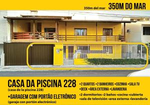 ein gelbes Haus mit einem Schild davor in der Unterkunft Soares Acomodações in Itapema