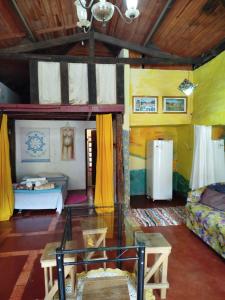 ein Wohnzimmer mit Sofa und Tisch in der Unterkunft Chalé de Pedra - Hospedaria in São Thomé das Letras