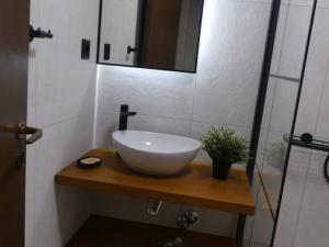 a bathroom with a white bowl sink on a wooden counter at Despina Apts by Estia in Gouves