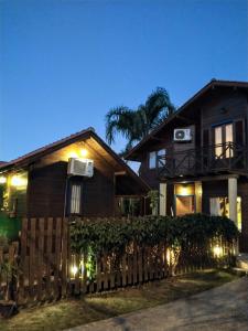 a house with lights in front of a fence at Long Life Campeche-Pousada in Florianópolis +59 photos