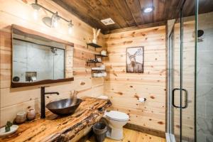 a wooden bathroom with a sink and a toilet at Brand New 3 Bedroom 3 Bath with Loft in Hochatown +54 photos