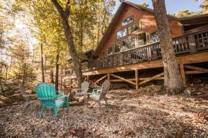 a wooden house with chairs and a table and a tree at Brand New 3 Bedroom 3 Bath with Loft in Hochatown