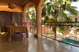 a room with a table and a balcony with palm trees at Appartement Cascade in Saly Portudal