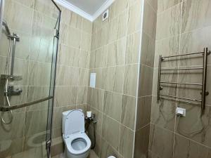a bathroom with a toilet and a glass shower at Nexpo City уютные апартаменты возле ЭКСПО in Prigorodnyy +23 photos