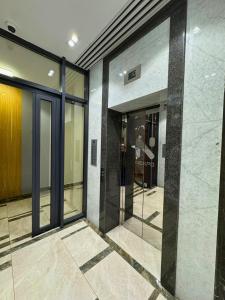 an empty lobby with glass doors in a building at Nexpo City уютные апартаменты возле ЭКСПО in Prigorodnyy