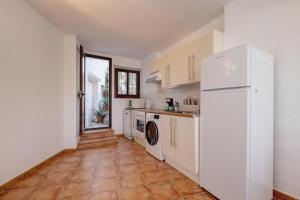 a kitchen with a white refrigerator and a tile floor at Apartament Ewa z widokiem Casares in Casares +8 photos