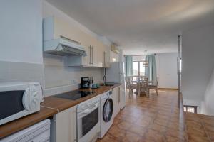 a kitchen with a sink and a microwave at Apartament Ewa z widokiem Casares in Casares