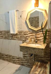 a bathroom with a sink and a mirror at Bangalô Maria Vista Mar, Luxo em Trancoso in Porto Seguro +15 photos