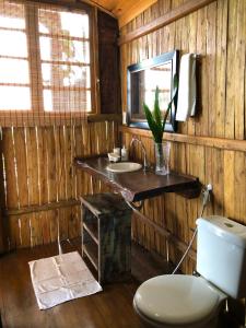 a bathroom with a toilet and a sink at Bangalô Maria Vista Mar, Luxo em Trancoso in Porto Seguro