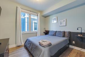 a bedroom with a large bed and a window at Walk to Shops on Front Street Traverse City Condo in Traverse City