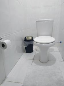 a white bathroom with a toilet and a trash can at Pousada 4 cantos in Corumbá +77 photos