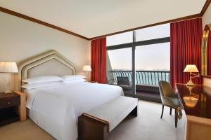 מיטה או מיטות בחדר ב-Sheraton Grand Doha Resort & Convention Hotel