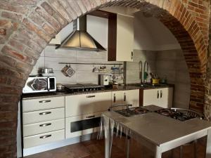 kuchnia z ceglaną ścianą i łukiem w obiekcie Via Roma 81 w mieście San Giovanni in Galdo